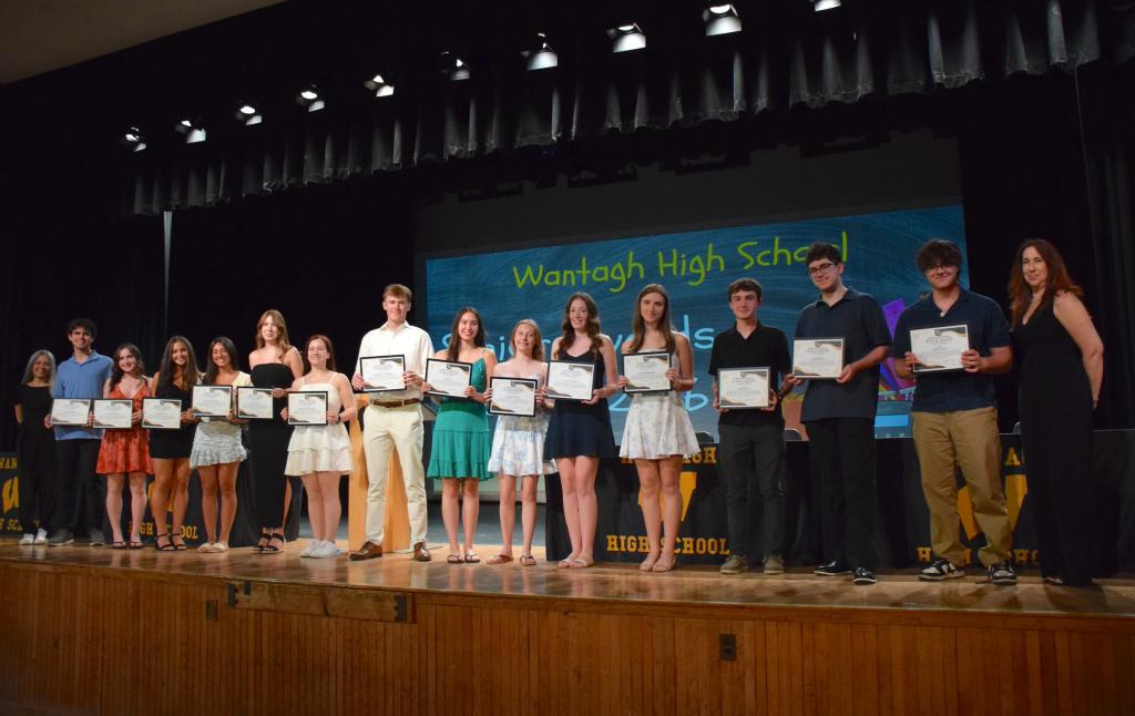 students on stage holding certificates